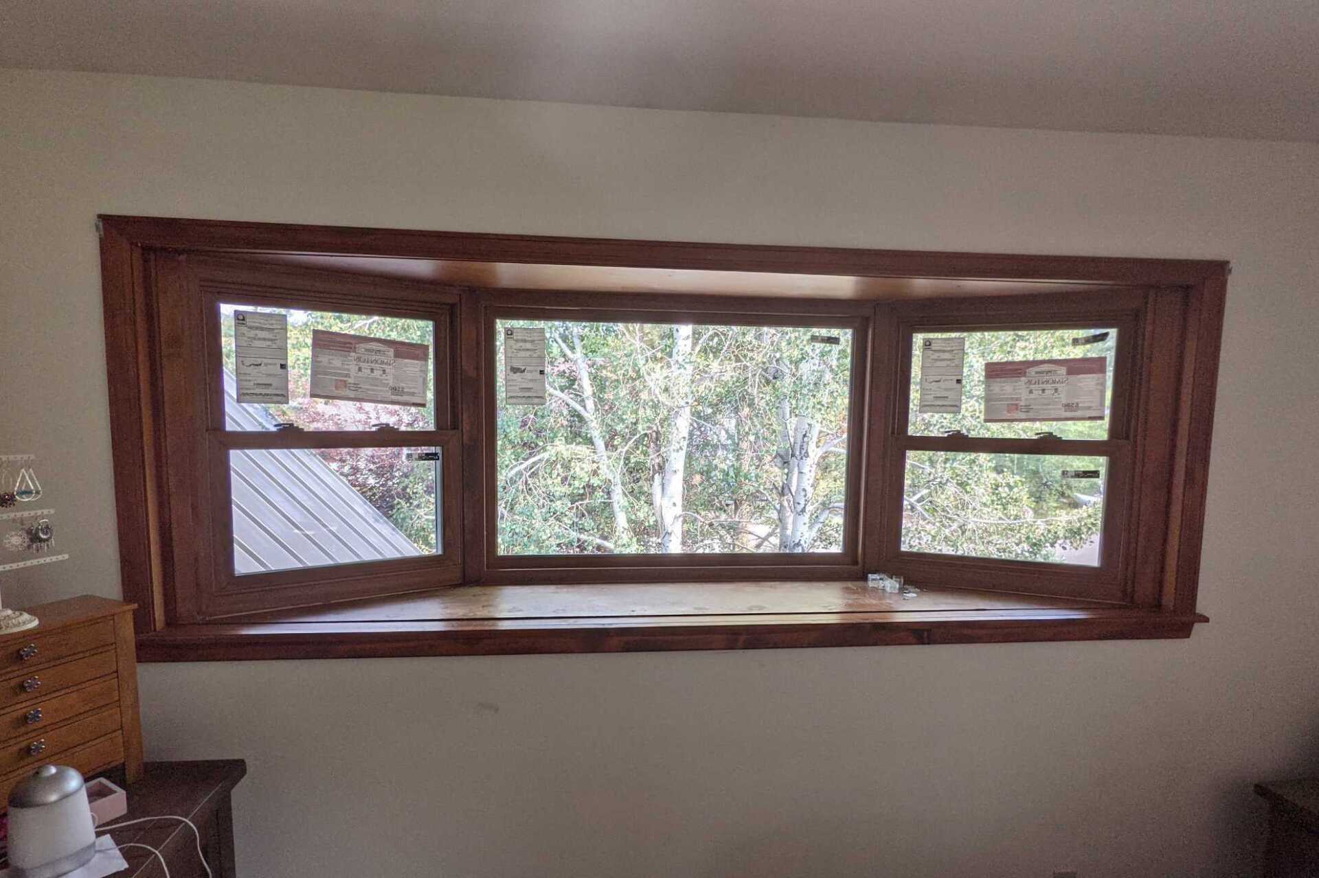 A large window in a room with a view of trees.