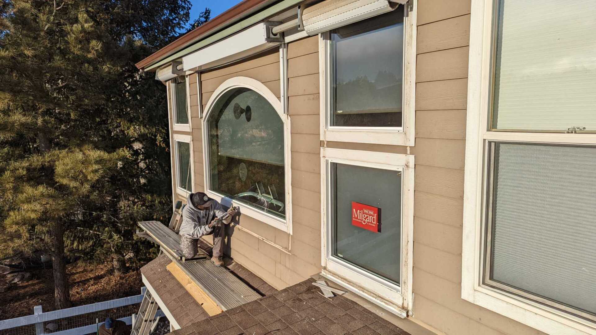 A man is working on the roof of a house.