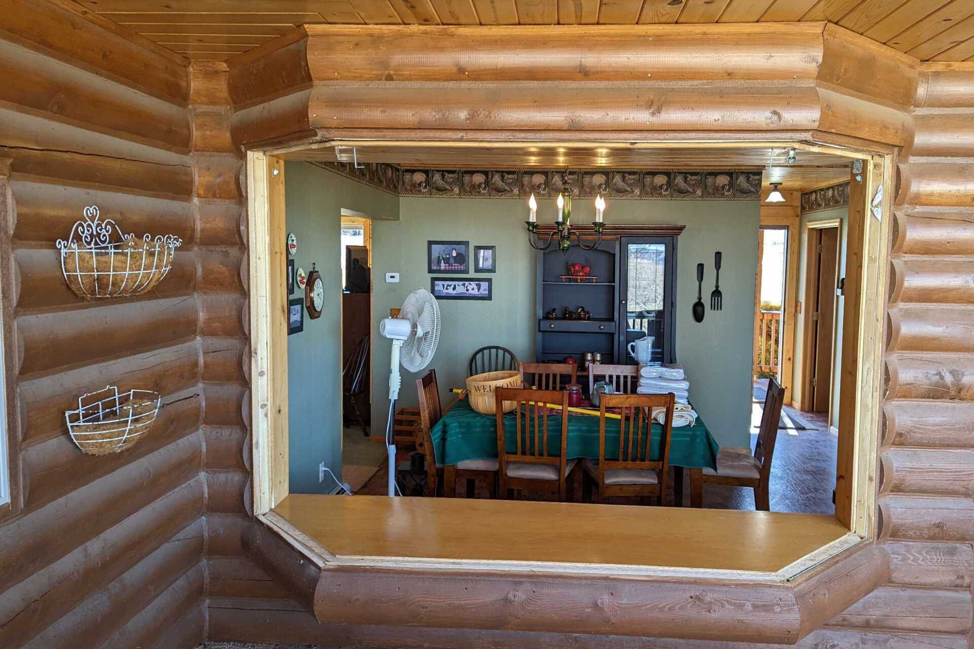 A dining room in a log cabin with a table and chairs