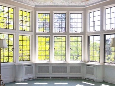 A room with lots of windows and a lamp