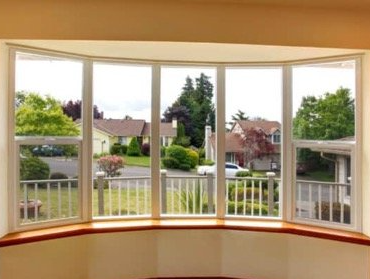 A bay window with a view of a residential area