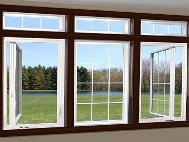 A large window with a view of a field and a lake.