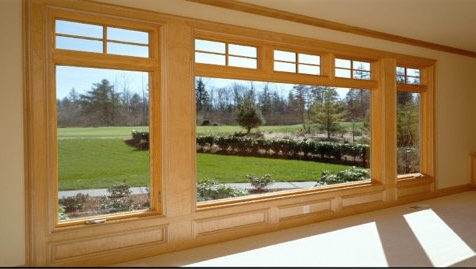 A large window with a view of a lush green field