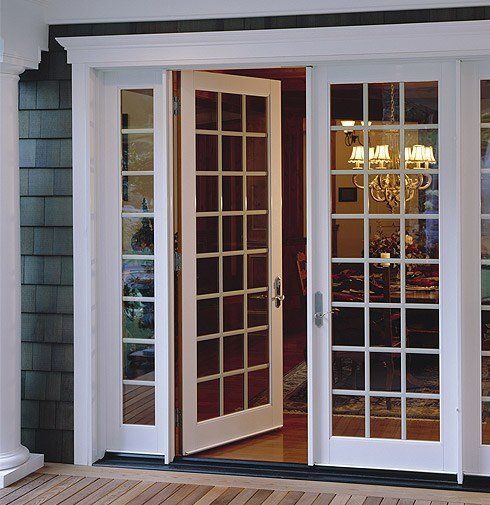 A white french door is open to a living room