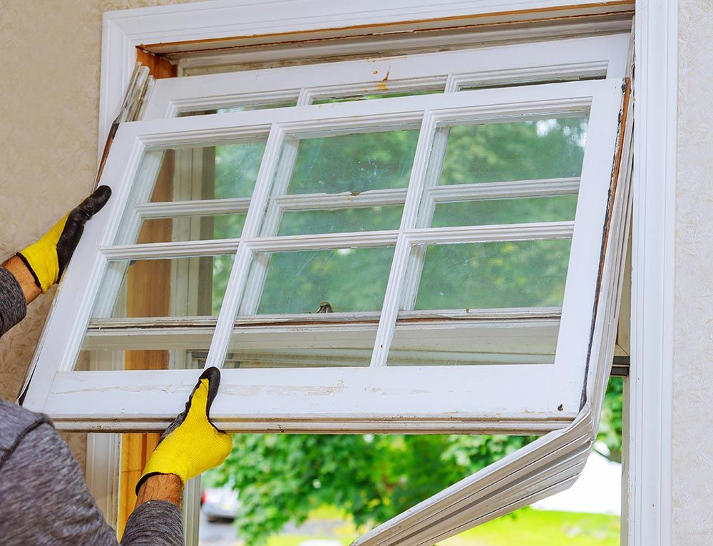 A man is installing a window in a house.