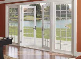 A living room with a pool table and sliding glass doors leading to a lake.