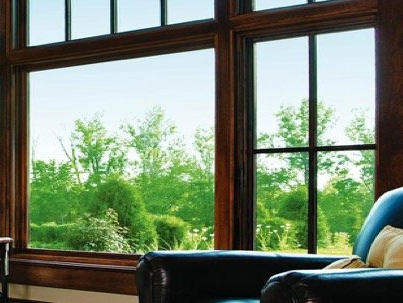 A living room with a blue chair and a large window