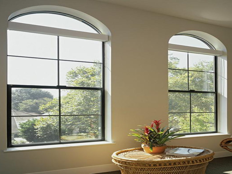 A living room with two arched windows and a wicker table
