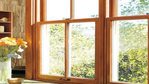A wooden window with a vase of flowers in front of it.