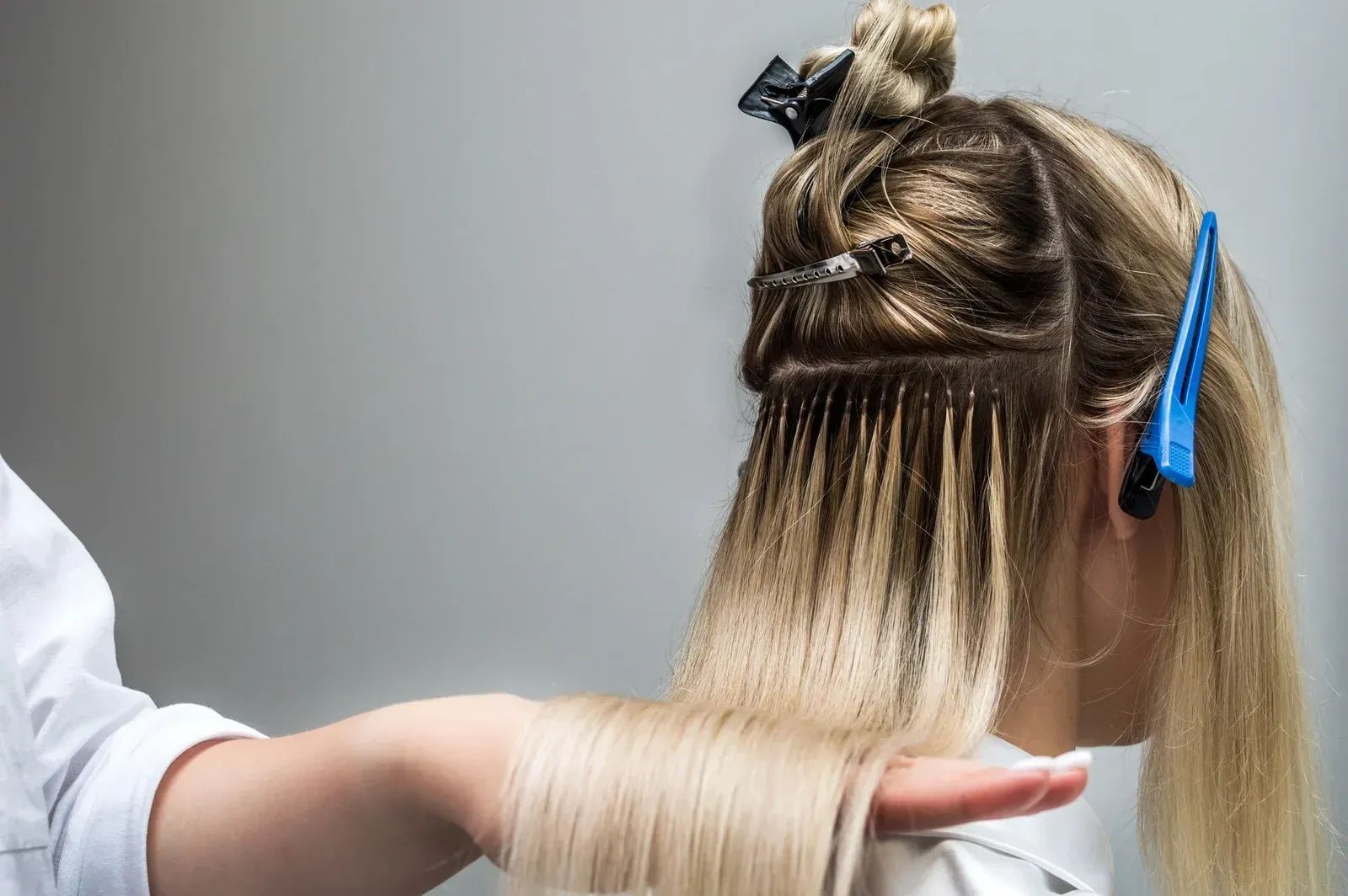 Hairdresser sectioning blonde hair with foils during a salon coloring treatment