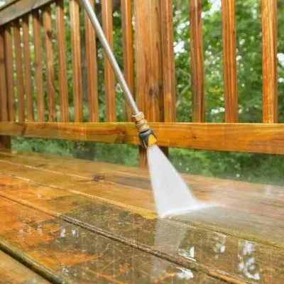 Water blasting a wooden deck to remove dirt and brighten timber boards in Waldronville, Dunedin.