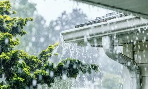 Overflowing gutter during rain showing blocked spouting and stormwater drainage issues in Dunedin.