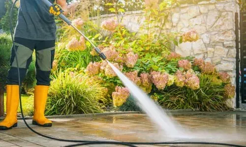 Council-compliant power washing of residential paving near garden landscaping in Dunedin.