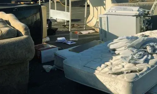 Household rubbish removal in Dunedin, showing a mattress, furniture, and whiteware ready for collection.