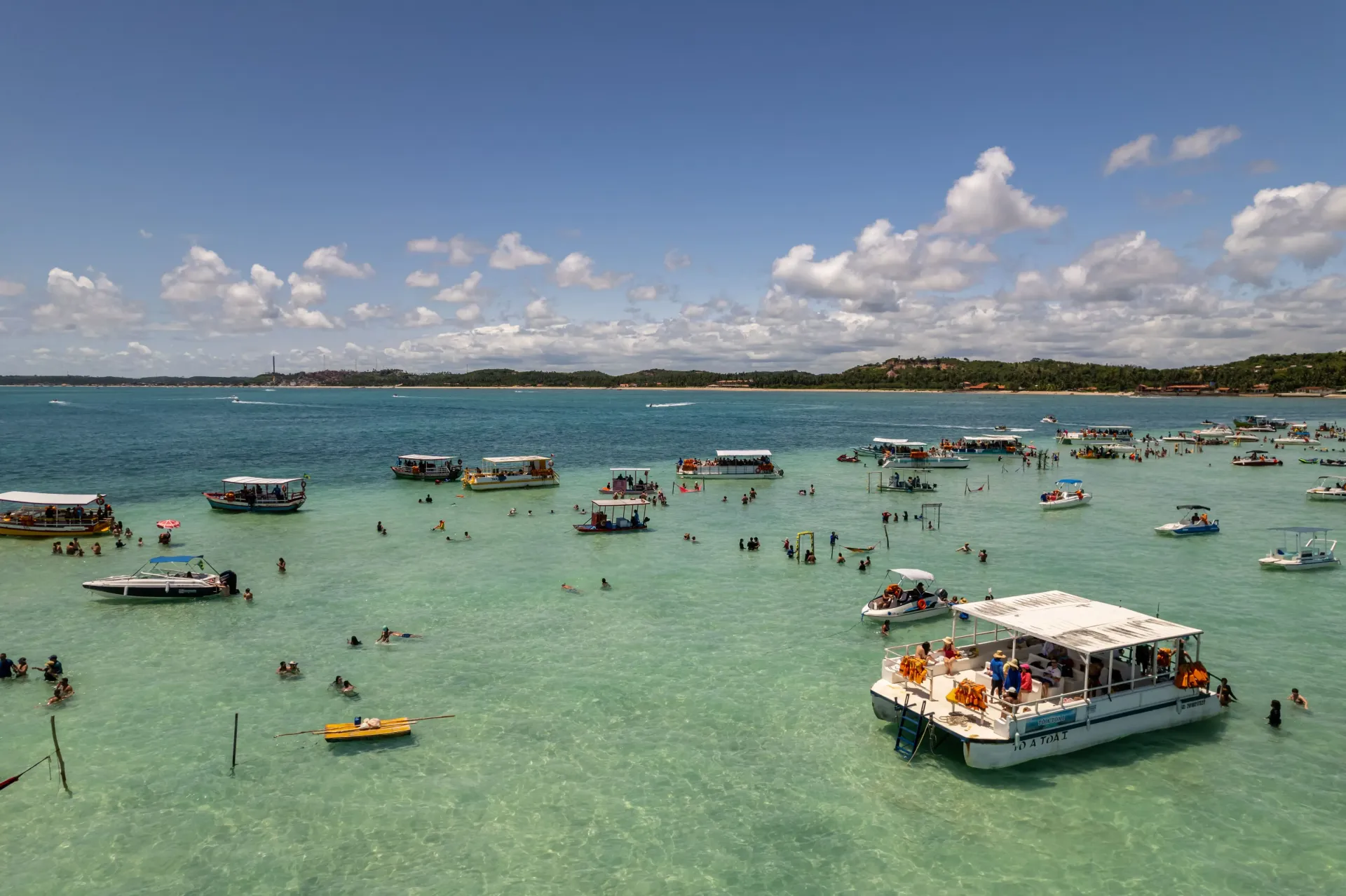 Um grupo de barcos está flutuando sobre um corpo d'água.-Hotel-Praia-Dourada-Maragogi-Park