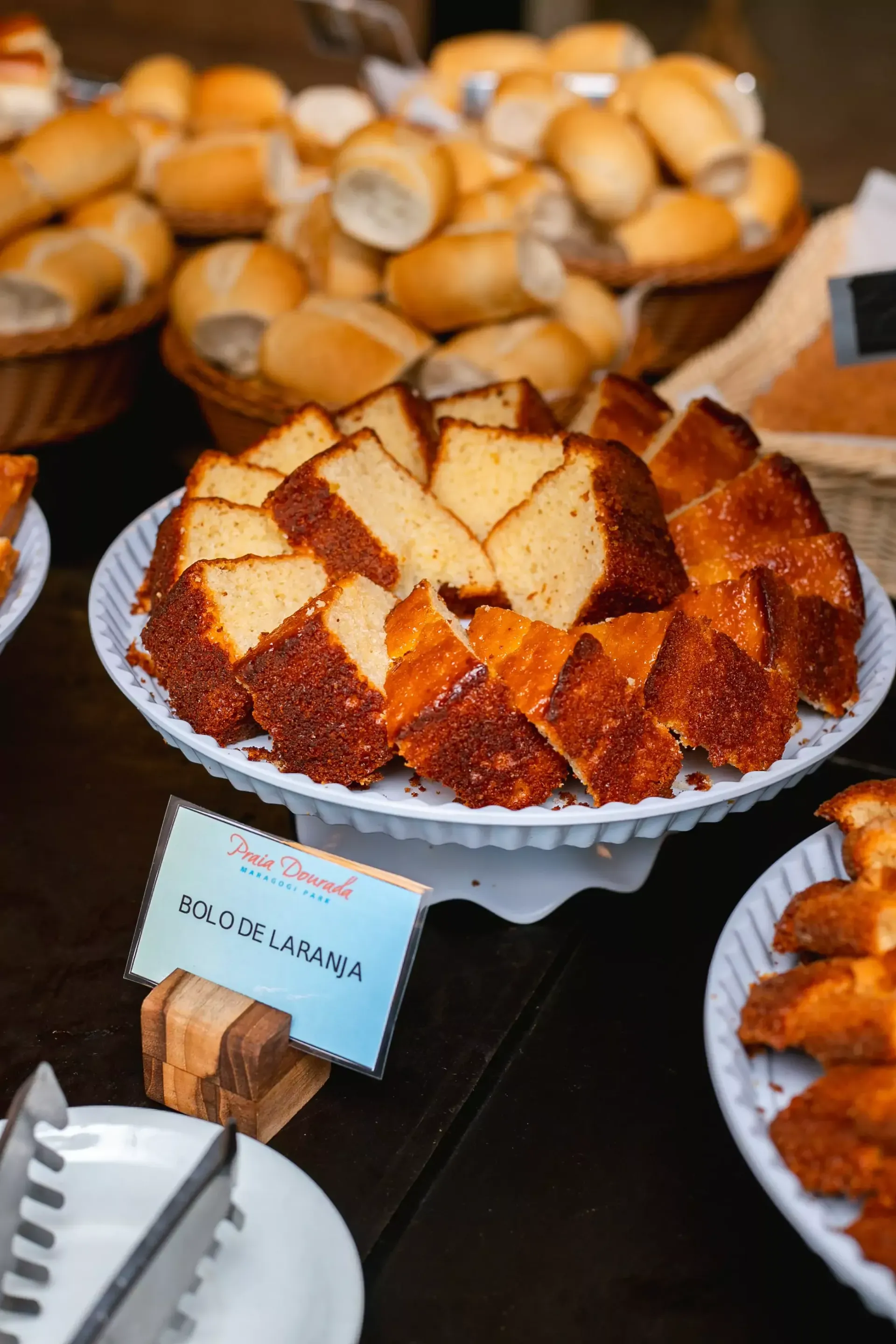 Um prato de pão e um prato de bolo sobre uma mesa.-Hotel-Praia-Dourada-Maragogi-Park
