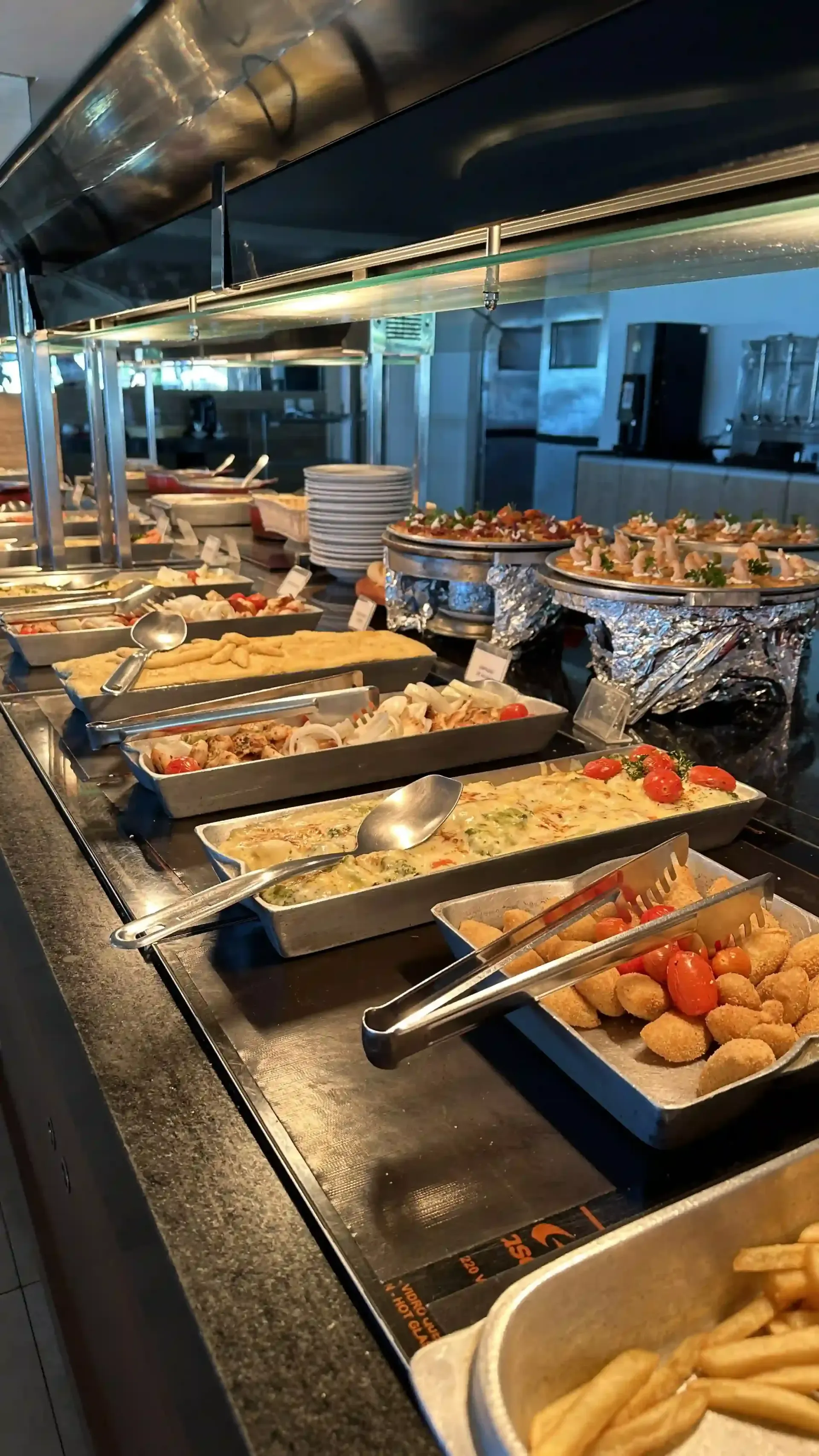 Um bufê cheio de comida e batatas fritas.-Hotel-Praia-Dourada-Maragogi-Park
