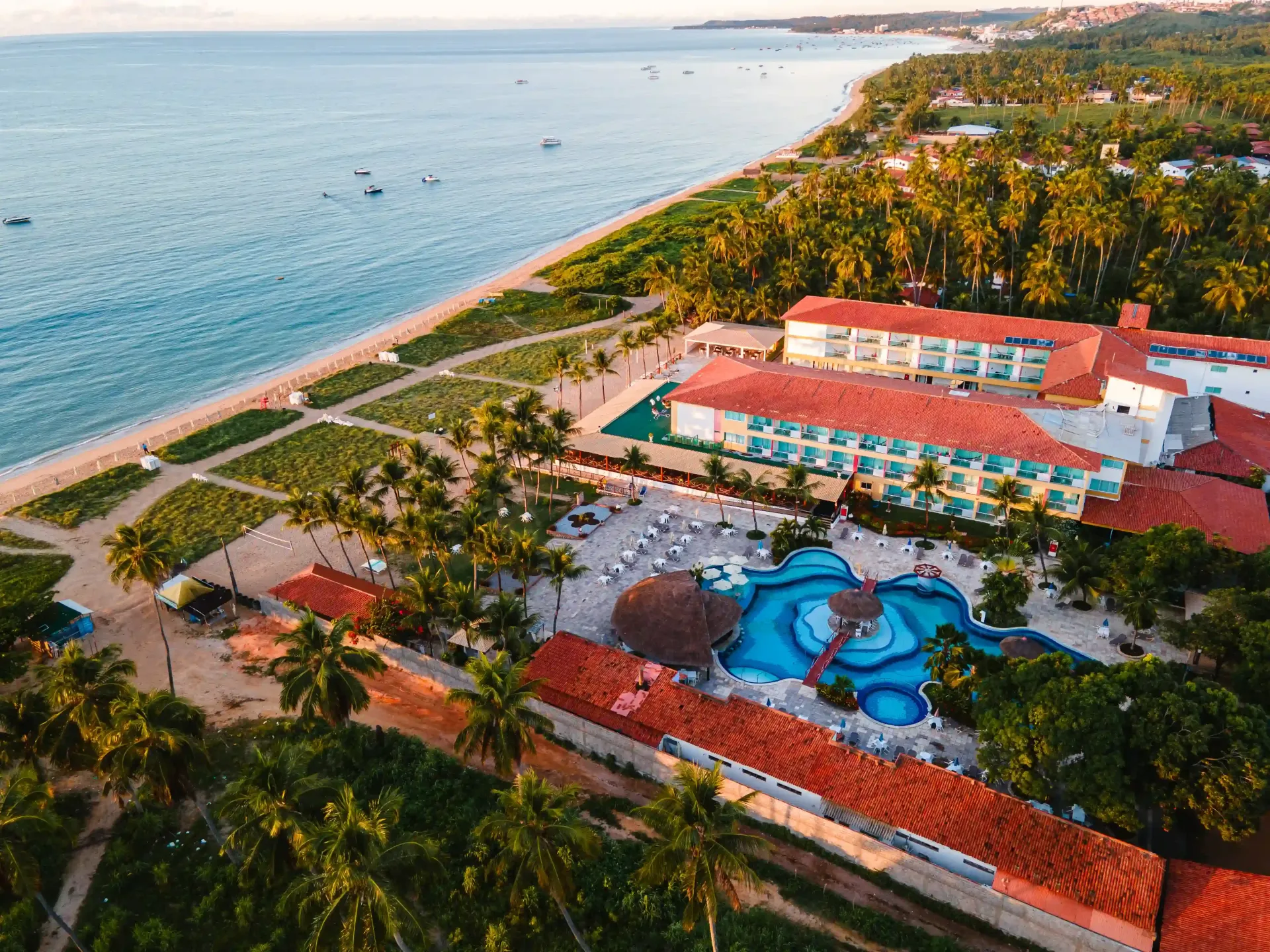 Uma vista aérea de um resort de praia com palmeiras e uma grande piscina.-Hotel-Praia-Dourada-Maragogi-Park