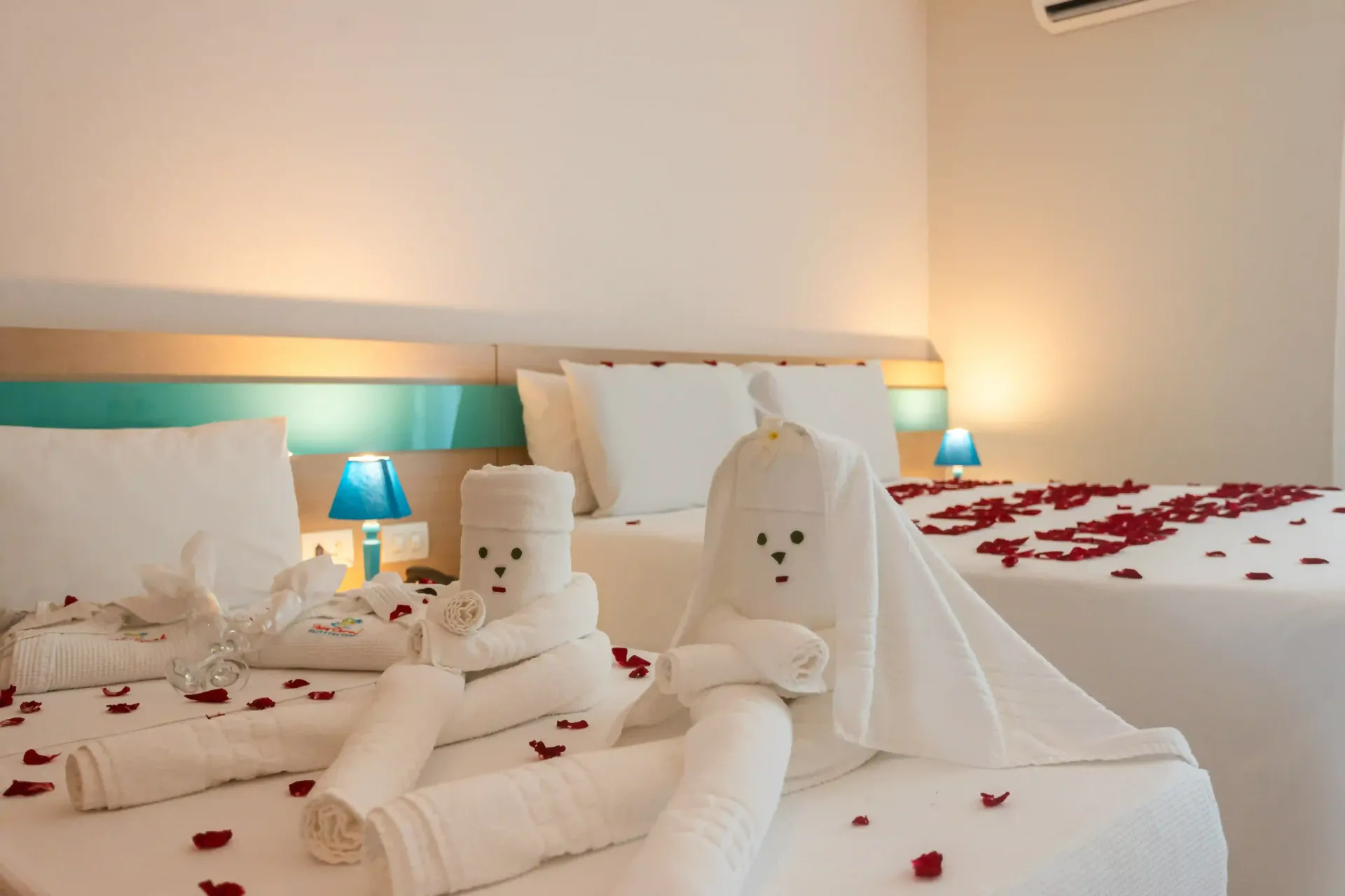 Um quarto de hotel com uma cama decorada com toalhas e pétalas de rosa.-Hotel-Praia-Dourada-Maragogi-Park