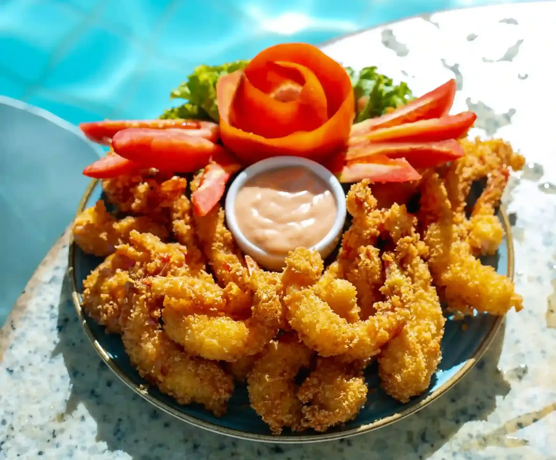 Um prato de camarão frito e vegetais em uma mesa ao lado de uma piscina.-Hotel-Praia-Dourada-Maragogi-Park