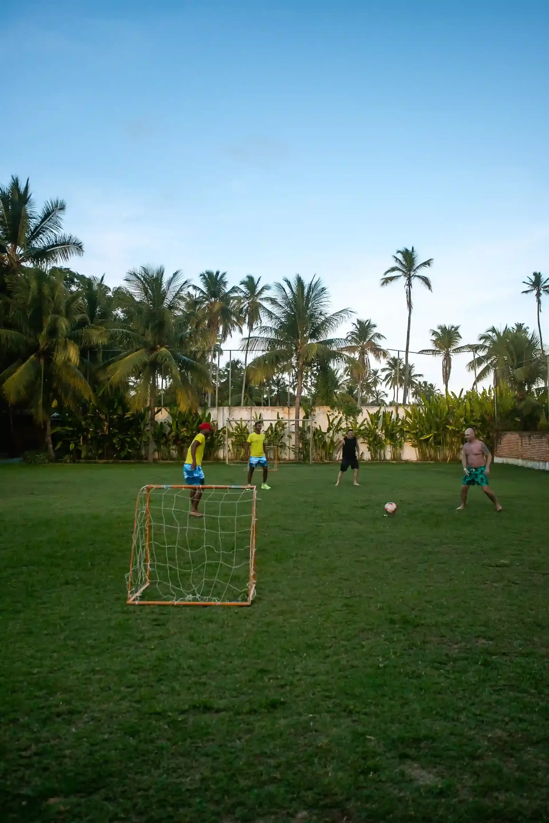 Um grupo de pessoas está jogando futebol em um campo verdejante.-Hotel-Praia-Dourada-Maragogi-Park