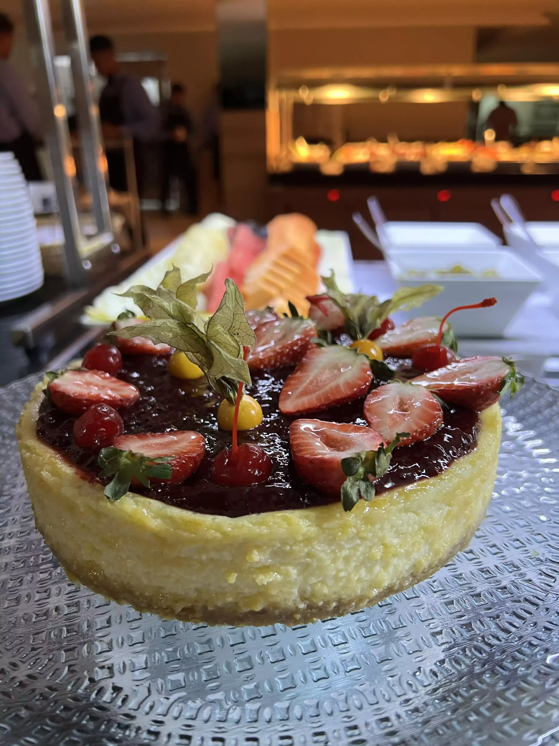 Tarte de morango com decoração de hortelã servida num prato de vidro num restaurante com iluminação suave.