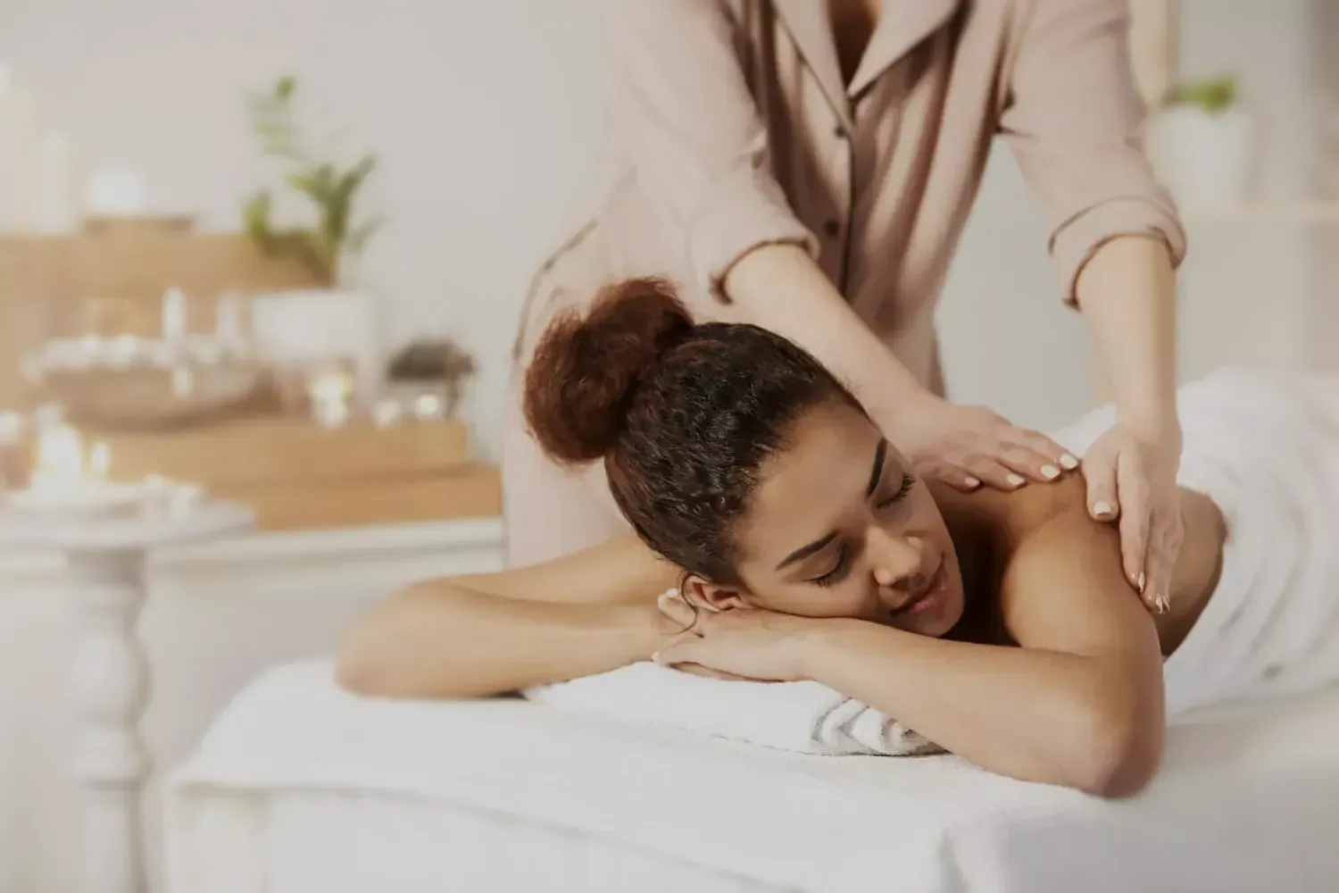 Massagista aplicando uma massagem nas costas de um cliente relaxado em uma sala de tratamento de spa.