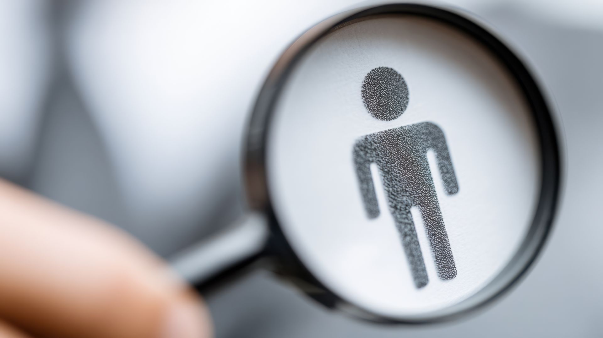 Magnifying glass over a person icon symbolizing recruitment and senior employment opportunities. Magnifying glass over a person icon symbolizing recruitment and senior employment opportunities.