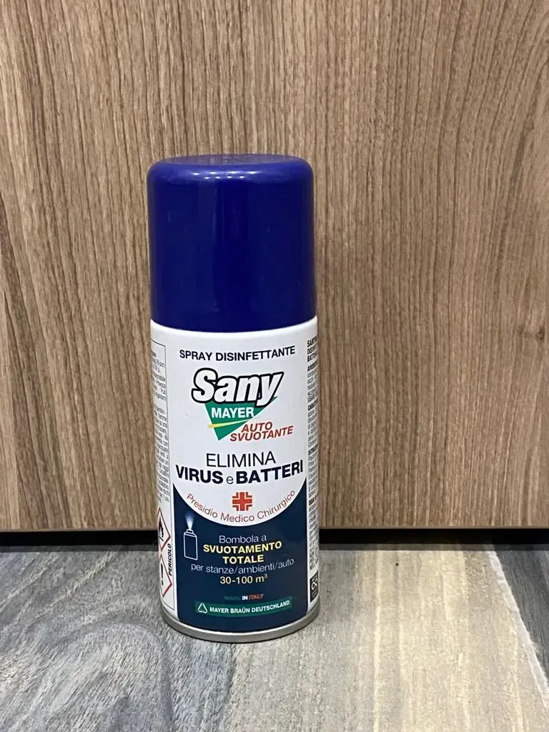 Bomboletta spray disinfettante Sany con tappo blu su una superficie di legno.