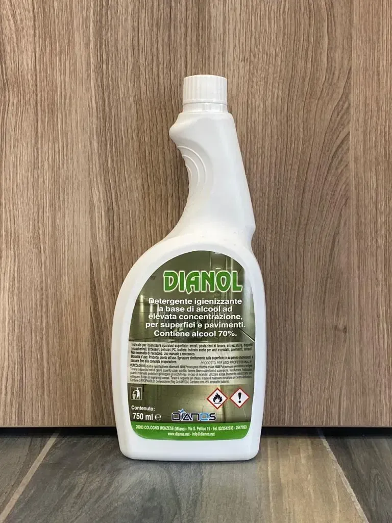 Flacone spray detergente bianco con etichetta verde su una superficie di legno.
