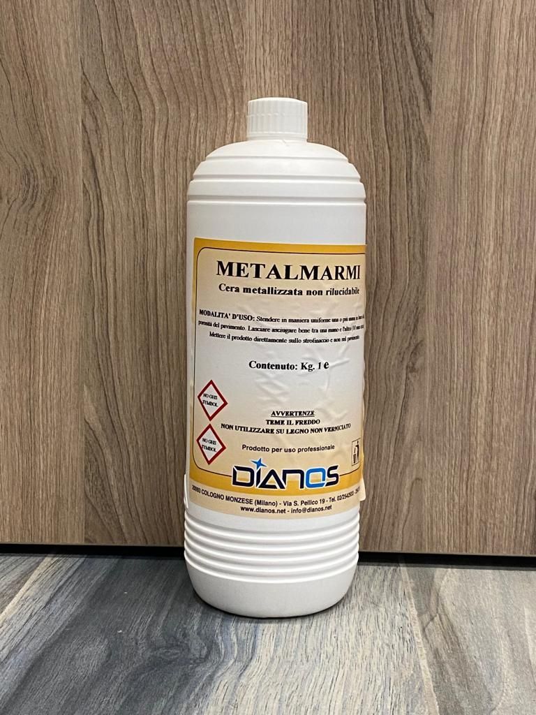 Bottiglia di plastica bianca contenente un detergente chimico con etichette di pericolo, appoggiata su un pavimento di legno contro una parete di legno.