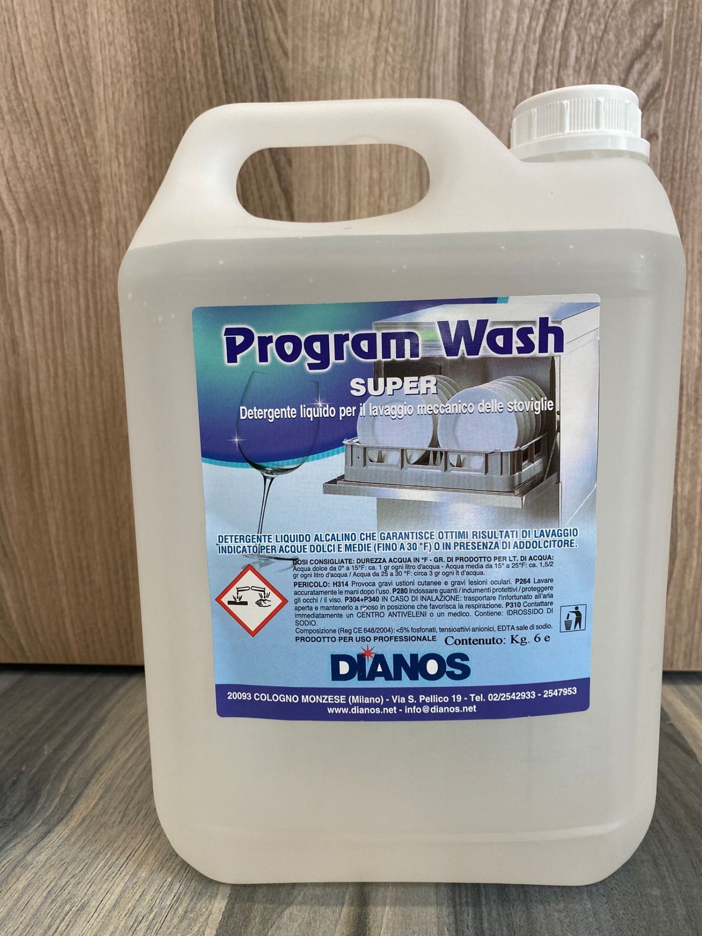 Tanica di plastica bianca di detergente Program Wash Super con manico ed etichetta blu su una superficie di legno.