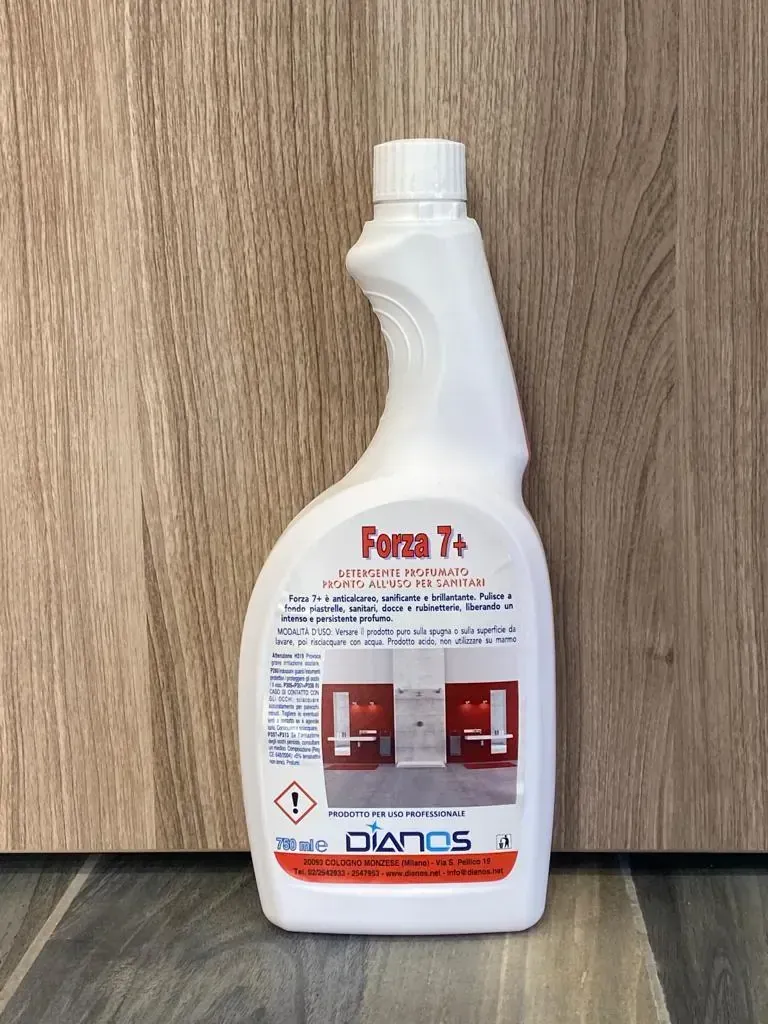 Flacone bianco di detergente chimico con etichetta rossa, appoggiato su una superficie di legno.