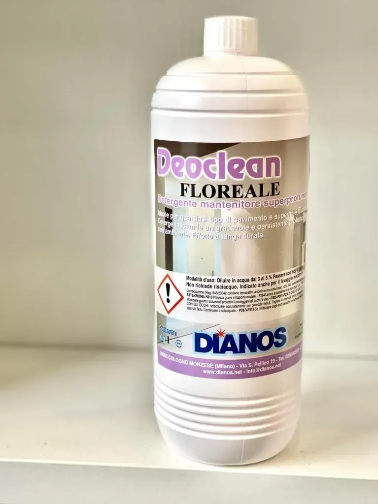 Flacone di plastica bianca di detergente floreale Deoclean con etichetta viola su uno scaffale