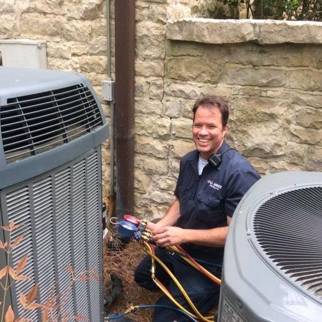 SJ Moore Heating and Air technician standing by a service van