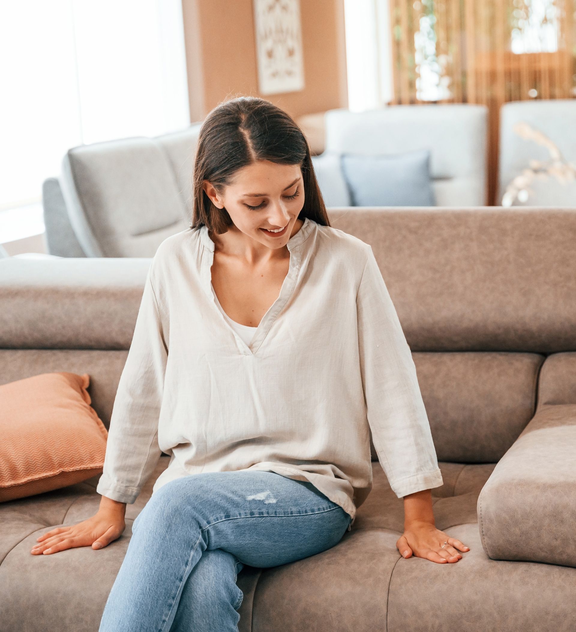 A Woman is Sitting on a Couch in a Living Room — We Clean Lounges In Palmview, QLD