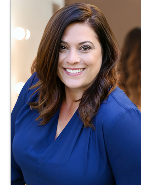 A woman in a blue shirt is smiling for the camera.