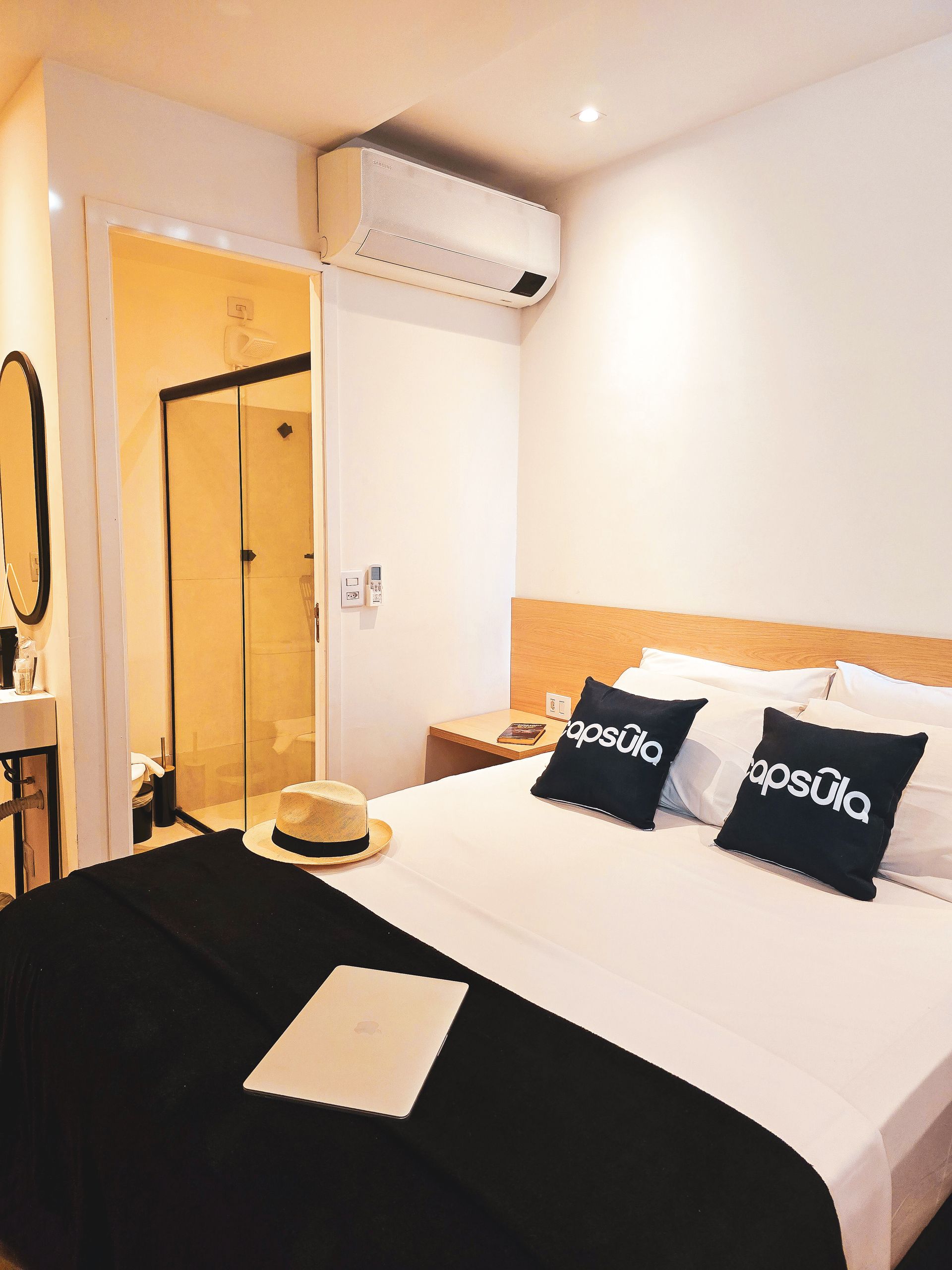 A hotel room with a bed , pillows and a hat