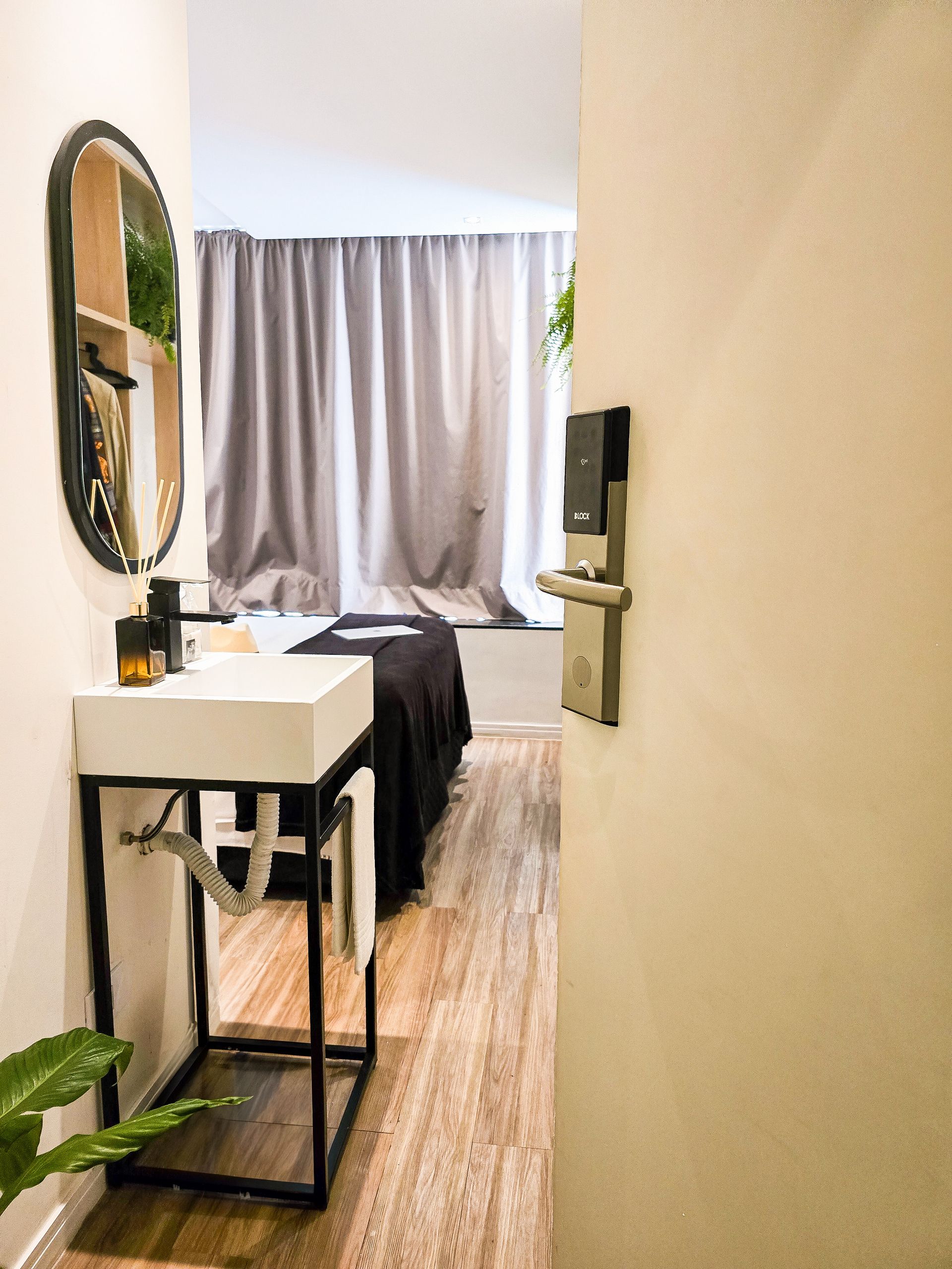 A bathroom with a sink , mirror , and bed.