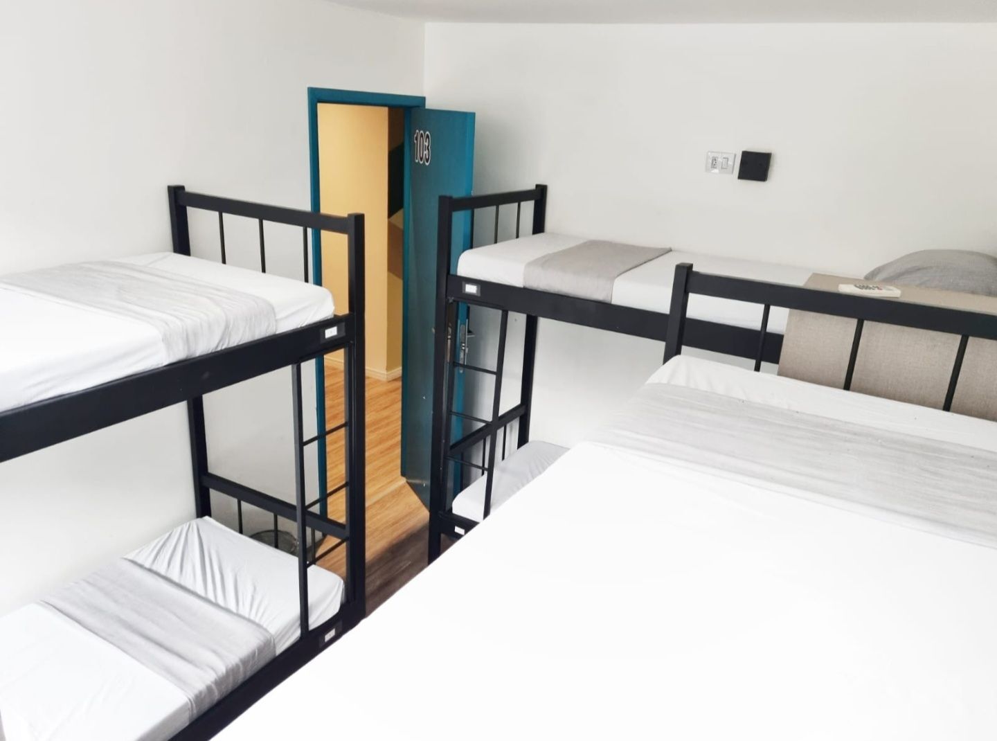 A room with four bunk beds and a door that is open.
