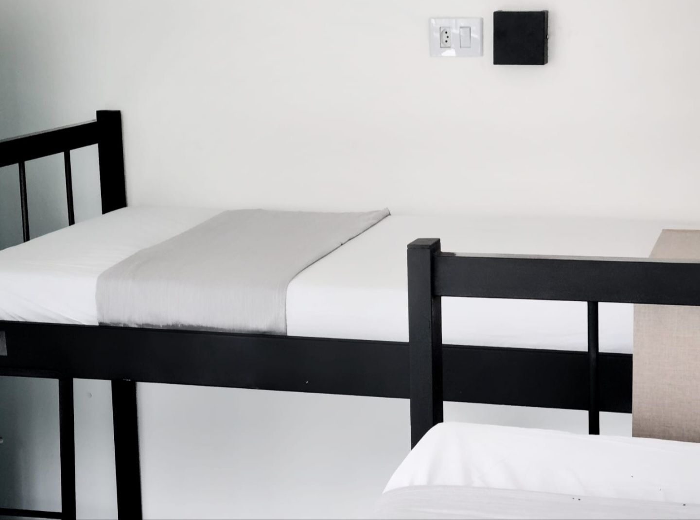 Two bunk beds in a room with white sheets