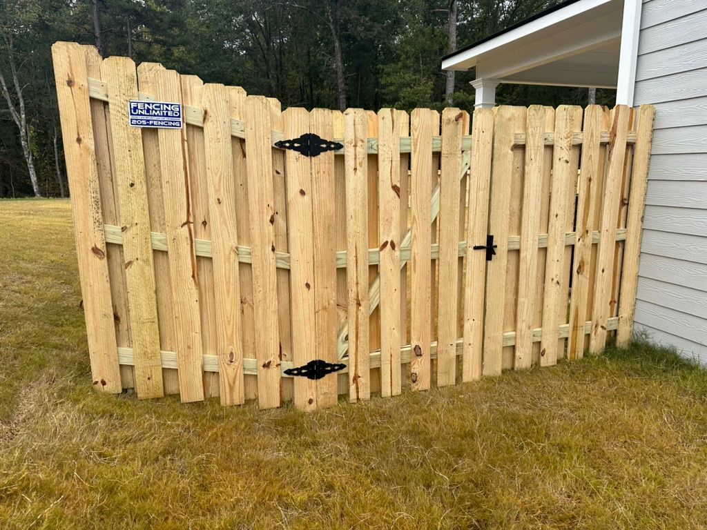 Wooden fence with two gates, connected to a house.