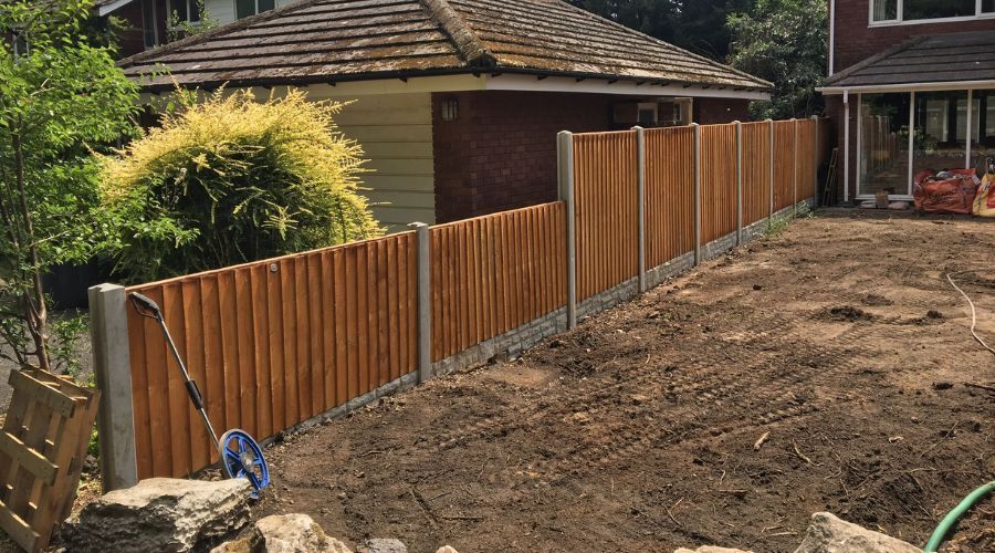 New wooden garden fence with concrete posts beside a backyard
