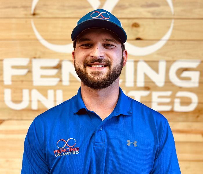 Man in blue polo and cap, smiling in front of