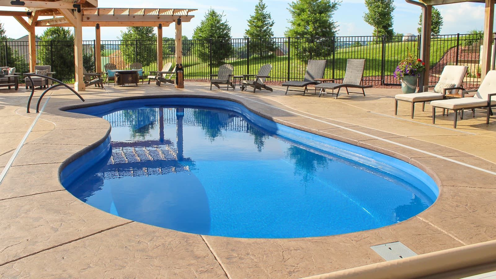 Outdoor resort pool with blue water, lounge chairs, and pergolas on a sunny day