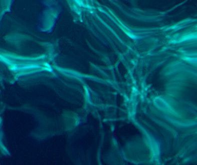 Abstract teal and blue wavy light patterns on a dark background