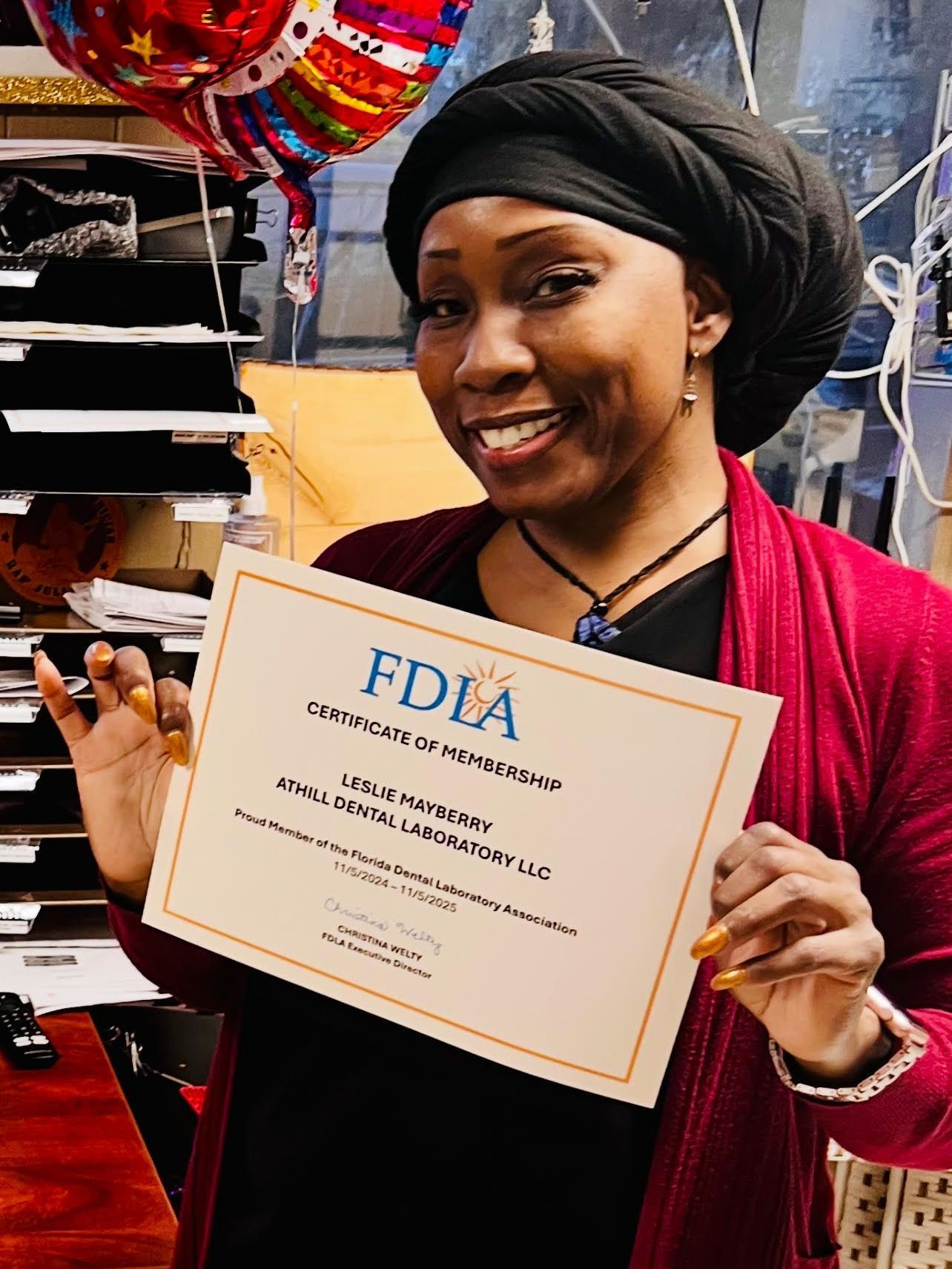 A woman is holding a certificate in her hands and smiling.