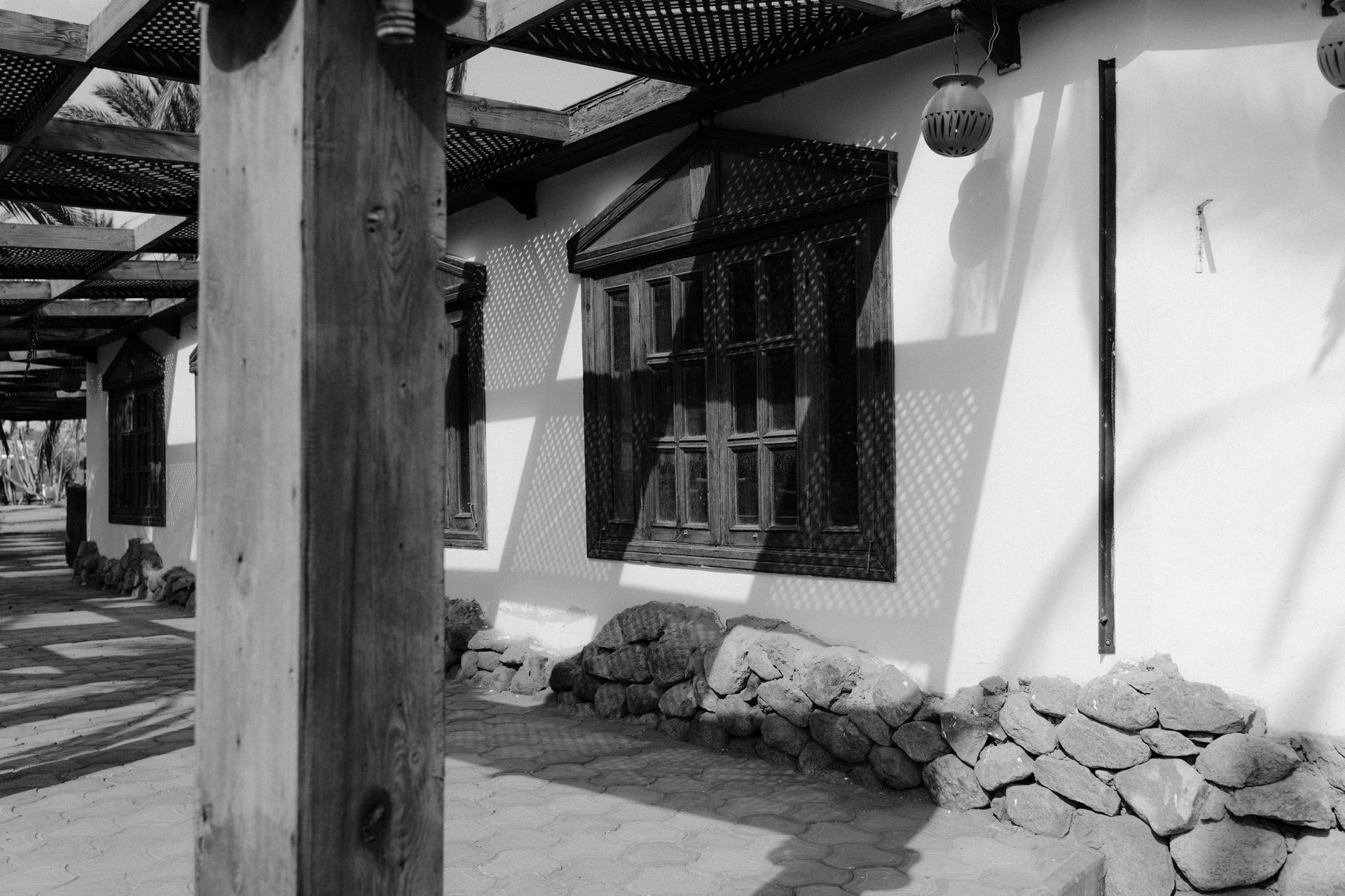 A black and white photo of a building with a wooden post in front of it