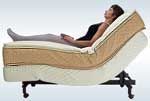 A woman is laying on an adjustable bed with her legs crossed.
