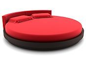 A round bed with red sheets and pillows on a white background. A round bed with red sheets and pillows on a white background.